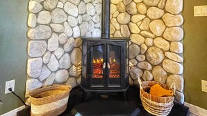 Eine Steinsäule mit Kamin, zwei Körben und einer schwarzen Matte.