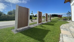 Une pelouse bien entretenue, avec un chemin de pierres menant à un bâtiment.