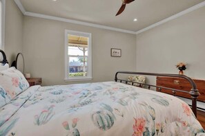 A bedroom with a bed, a window, a ceiling fan, and a dresser. - Hot Tub + Fire Pit | Wine Country | Near Main St (Fredericksburg)