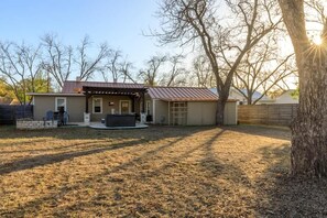 A residential property with a covered patio, a barbecue area, and a fenced yard.