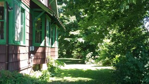 Ein grünes Holzhaus mit Veranda und Rasen.