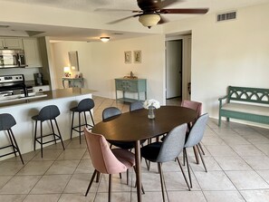 A modern kitchen with a central island, bar stools, and a dining table with chairs. - Wonderful 3 bedroom/2 bath, close to everything! (Scottsdale)