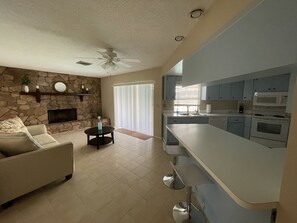 Relax in this stylish living space with a cozy fireplace, comfortable sofa, and dining area.