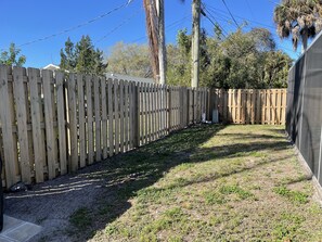 Enjoy an outdoor space with a patio and grassy area surrounded by trees.