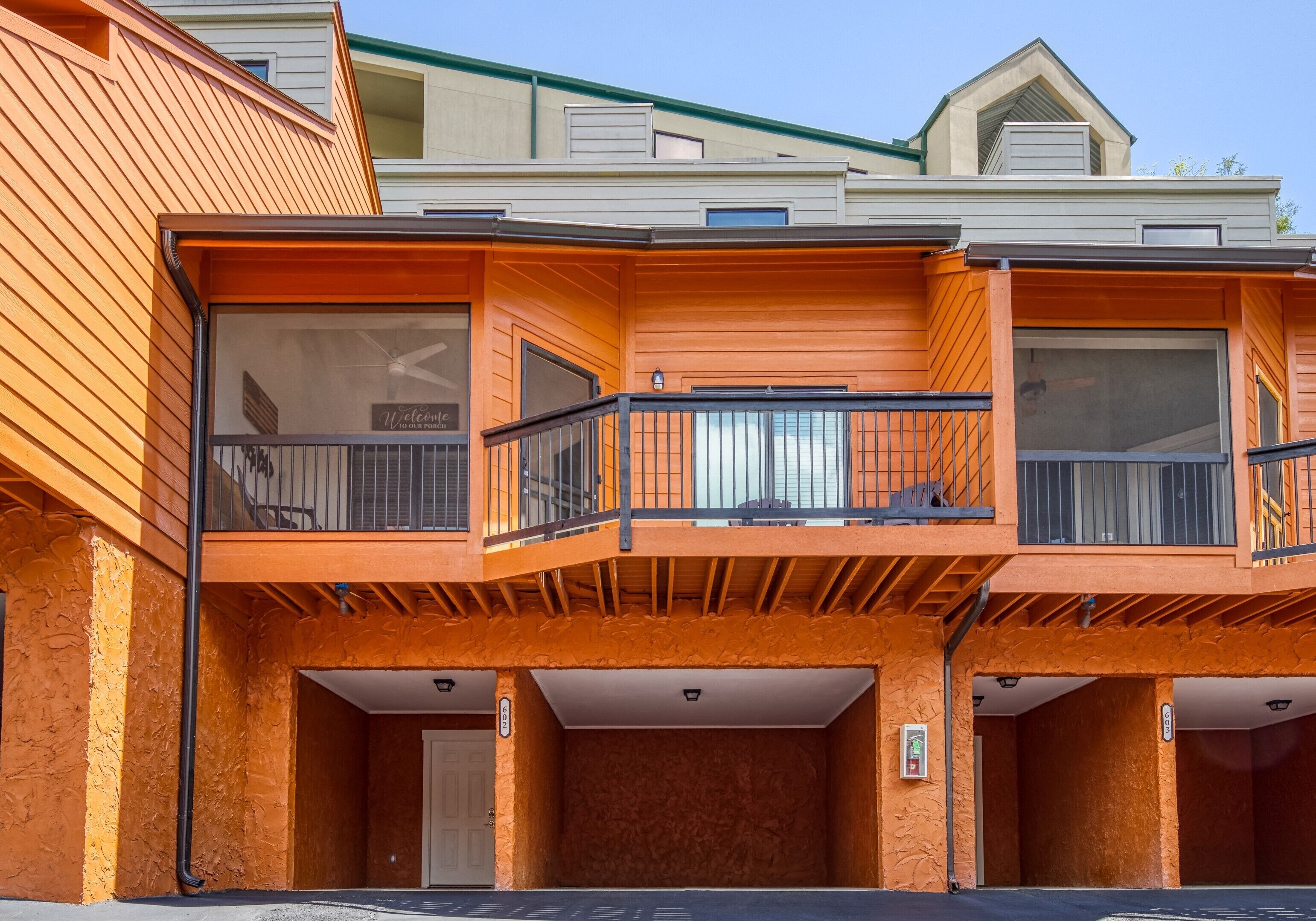 A multi-story building with a wooden facade, balconies, and a garage entrance.