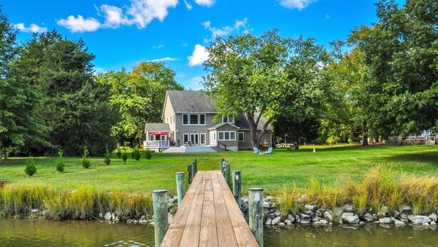 A house with a dock leading to a pond, surrounded by trees and a well-maintained lawn. - Tranquil  Beautiful Waterfront  Near Historic St. Michaels & Royal Oak (easton)