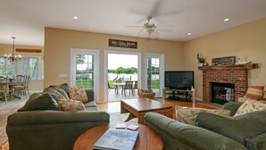 A spacious living room with a fireplace, comfortable seating, and a television. - Tranquil  Beautiful Waterfront  Near Historic St. Michaels & Royal Oak (easton)