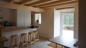 A modern kitchen with wooden beams, a built-in oven, and a window overlooking a garden. - Unique Experience in the Heart of Nature (Chãos)