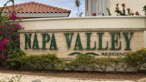 A sign for Napa Valley Residences with a clear view of the name and a landscaped area with rocks and plants. - Aruba 2-bedroom duplex for rent. 4 minutes to Eagle Beach and close to shopping. (Noord)