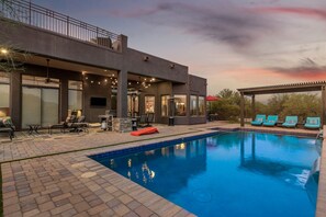 A modern outdoor pool area with a covered seating area and lounge chairs. - Desert Tranquility 4 Bedroom with Heated Pool (Scottsdale)