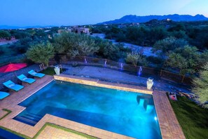A swimming pool with lounge chairs and a view of the surrounding landscape. - Desert Tranquility 4 Bedroom with Heated Pool (Scottsdale)