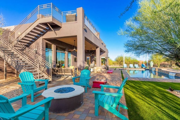 A modern outdoor patio with a fire pit, outdoor seating, and a pool. - Desert Tranquility 4 Bedroom with Heated Pool (Scottsdale)