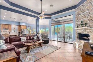 A spacious living room with a leather sofa, a coffee table, and a fireplace.