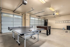 A spacious indoor area with a ping pong table, a foosball table, and a billiards table. - Desert Tranquility 4 Bedroom with Heated Pool (Scottsdale)