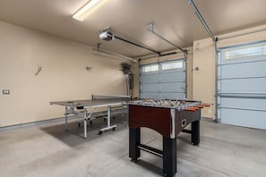 A spacious indoor area with a foosball table, ping pong table, and a ceiling-mounted projector. - Desert Tranquility 4 Bedroom with Heated Pool (Scottsdale)