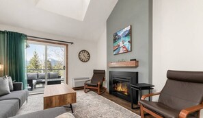 Una sala moderna con chimenea, zona de estar y vistas al exterior.
