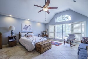 A bedroom with a bed, a chest of drawers, a nightstand, a lamp, a chair, a window with blinds, and a ceiling fan. - Beautiful Open Floorplan Home with Pool few min drive to Lake Austin & Travis (Austin)