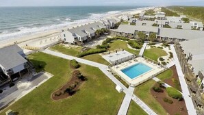 A coastal hotel with a pool, beach access, and a view of the ocean.