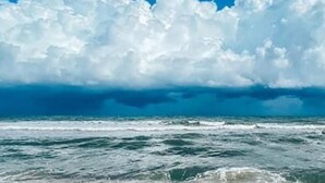 A beach with waves and a clear sky.