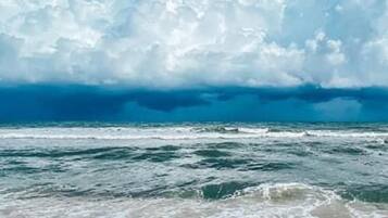 A beach with waves and a clear sky.