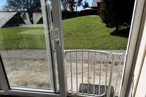 Stroll through the beautifully maintained outdoor area, featuring a lush lawn and a scenic hillside view.