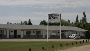 Shellbrook Motel met een bord waarop faciliteiten staan vermeld zoals airconditioning, kabeltelevisie en draadloos internet.