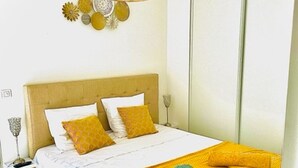 Une chambre à coucher avec un lit, une table de chevet, une lampe et un élément décoratif mural.