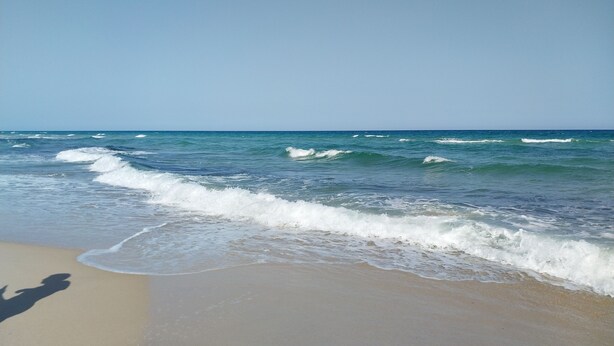 Ein Strand mit ankommenden Wellen.