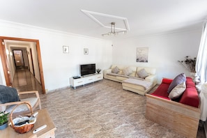 A living room with a sofa, TV, and a wooden cabinet.