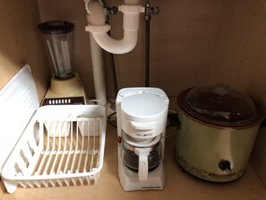 A kitchen with a coffee maker, a slow cooker, and a blender. - Town N' Country Motel (Canistota)