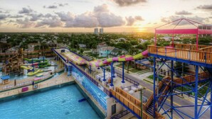 Un parc aquatique doté d’un grand toboggan aquatique, d’une piscine et d’une terrasse en bois.