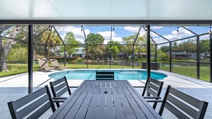 A covered patio with a pool, outdoor seating, and a view of the surrounding area. - Pool Home That Backs Up to Water- Only 20 Miles to Beautiful Florida Beaches! (Palmetto)
