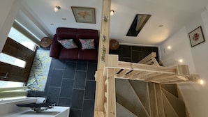 A modern interior with a wooden bunk bed, a red sofa, and a dining area. - Beautiful Robins Nest barn, Close to Minack, Porthcurno, Sennen, Sea ,beaches (Penzance)