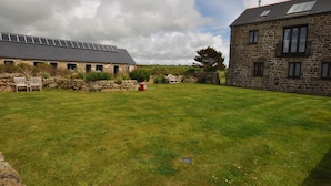 A stone building with a sloped roof and a solar panel array. - Beautiful Robins Nest barn, Close to Minack, Porthcurno, Sennen, Sea ,beaches (Penzance)