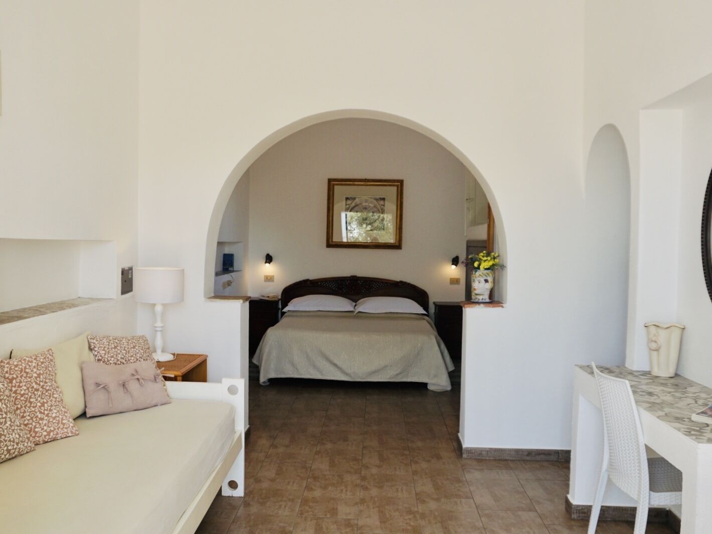 Un dormitorio con cama, escritorio y sofá.