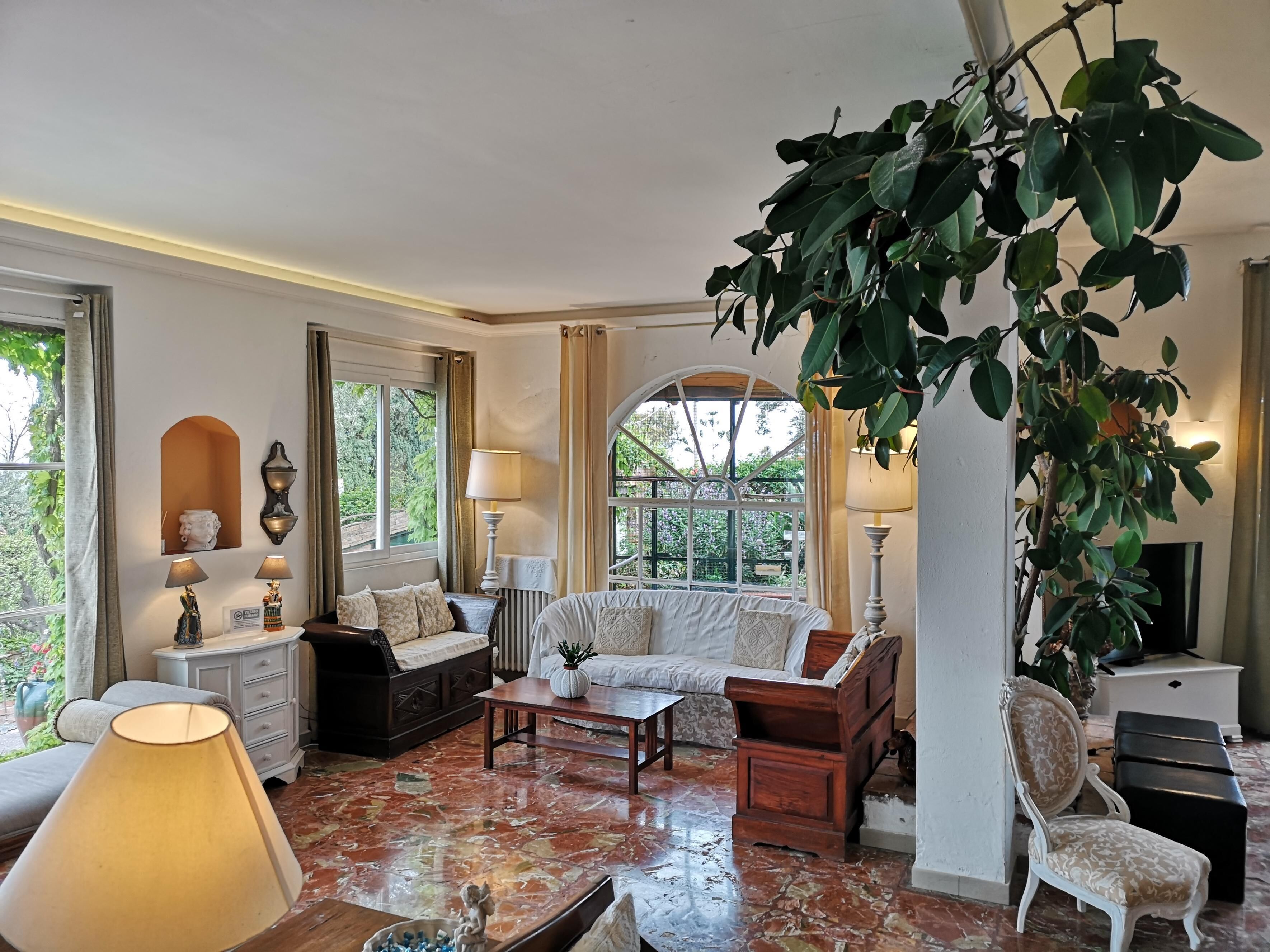 A spacious living room with a large window, a fireplace, and a variety of seating options.
