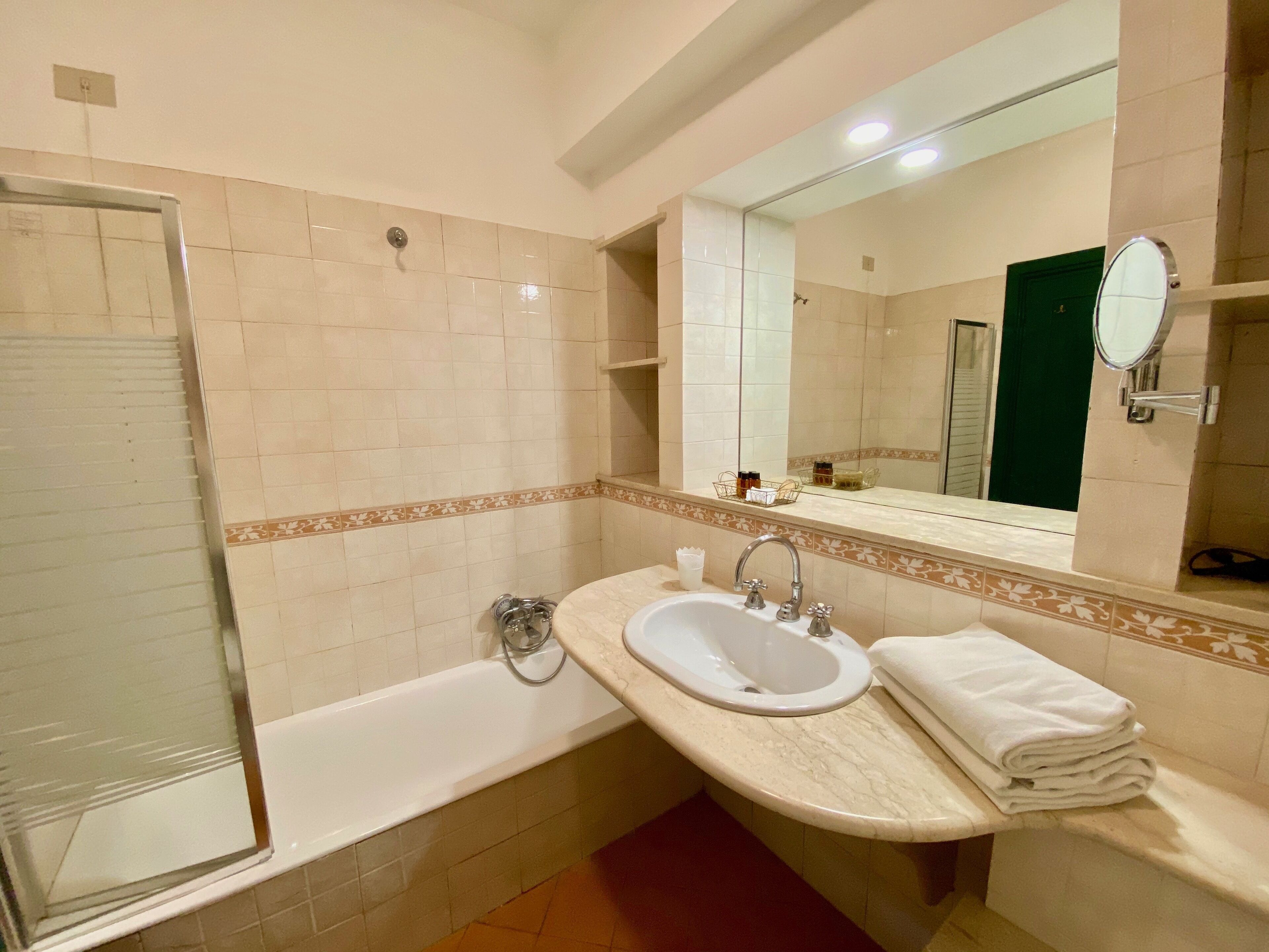 A bathroom with a bathtub, a sink, and a mirror.