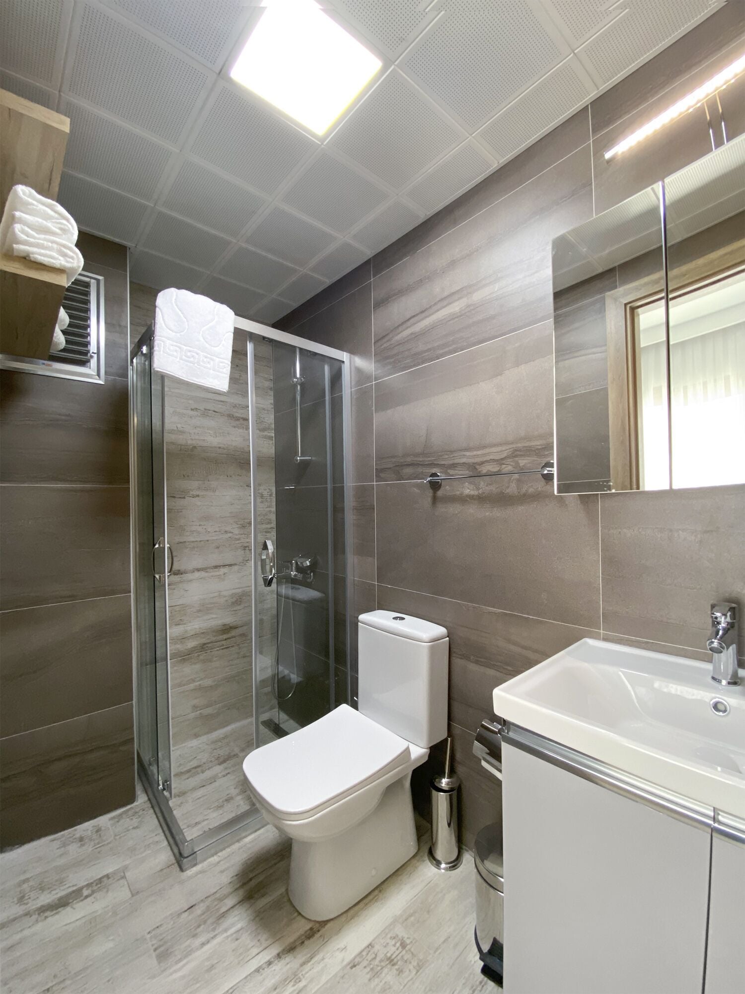 Ein modernes Badezimmer mit einer Duschkabine, einer Toilette und einem Waschbecken.