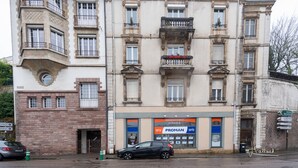 A multi-story building with a prominent corner tower and a ground-level entrance. - SPACIOUS, EXCEPTIONAL APARTMENT (Épinal)