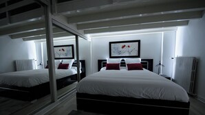 A modern hotel room with two beds, a large mirror, and artwork on the walls. - SPACIOUS, EXCEPTIONAL APARTMENT (Épinal)