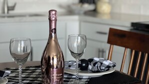 A bottle of Pitar's Prosecco on a table with two glasses. - ELEVATE IN THE SUN! A Renovated Beachfront Condo! (Fort Myers Beach)