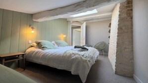 A bedroom with a bed, bedside table, and a chair. There is a window with natural light and a door leading to another room. - Exceptional setting, many points of interest (Prailles-La Couarde)