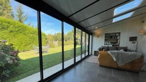 A modern living room with large glass doors leading to a garden. - Exceptional setting, many points of interest (Prailles-La Couarde)