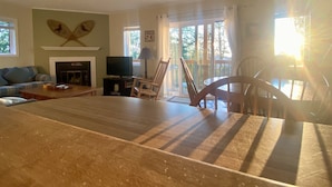 A living room with a fireplace, television, and a dining area with a table and chairs. - APPresSki - 5 bed Ski in Ski out - 50 Steps to Ski Sugar Mountain Slopes (Sugar Mountain)