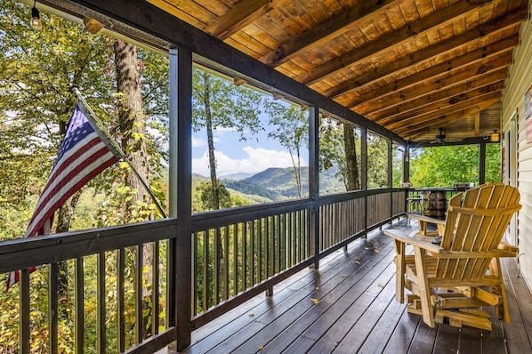 Eine Holterrasse mit Blick auf eine Berglandschaft, eine amerikanische Flagge und zwei Adirondack-Stühle.