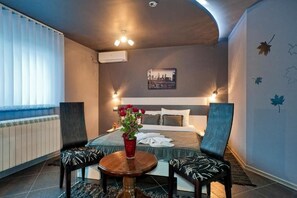 Relax in a stylish room with a large bed, bedside table, and comfortable chairs.
