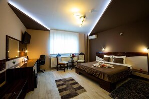 Relax in a stylish room with a large bed, desk, and comfortable seating area.