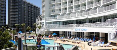 Un hotel con varios balcones, una zona de piscina con tumbonas y un cartel que dice "NORTH TOWER".