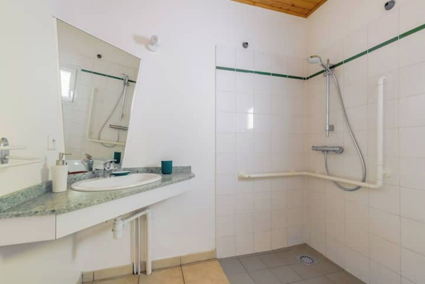 Un bagno con lavandino, specchio e doccia.