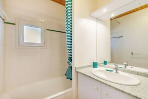Bathtub, hair dryer, soap, toilet paper